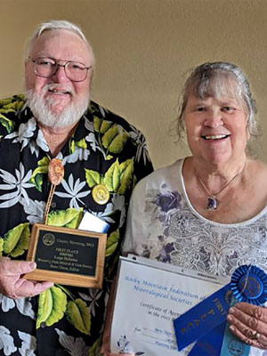 Jim Gray, WSGMS President, presents Jade State News Editor Ilene Olson with the regional first-place ribbon and plaque during the
		Regional Rock Show in July 2023